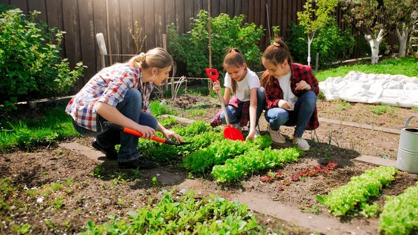 Foto dua gadis remaja dengan ibu bekerja di kebun belakang — Stok Foto