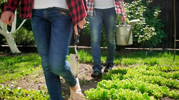 Foto de primer plano de la familia caminando en el jardín del patio trasero con herramientas de jardinería —  Fotos de Stock