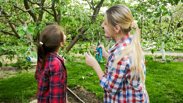 Portrait of young woman with daughter in blossoming orchard — Stock Photo, Image
