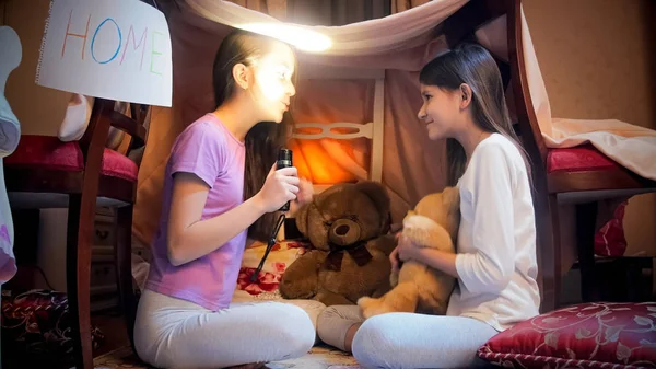 Two cute girls having pajamas party at night and telling stories — Stock Photo, Image