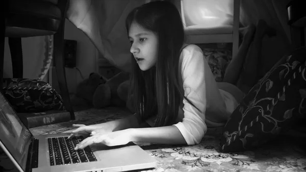 Black and white portrait of girl using laptop at night — Stock Photo, Image