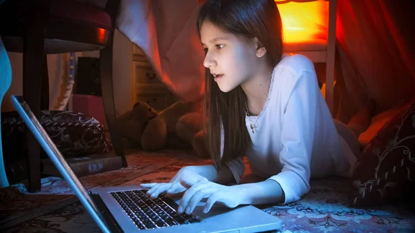 Portrait de fille mignonne couchée sur le sol à la tente dans la chambre et à l'aide d'un ordinateur portable — Photo