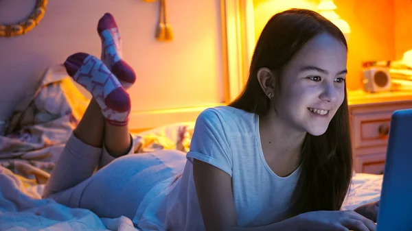 Portret uśmiechający się nastolatkę, leżąc w łóżku w nocy i po konferencji wideo — Zdjęcie stockowe