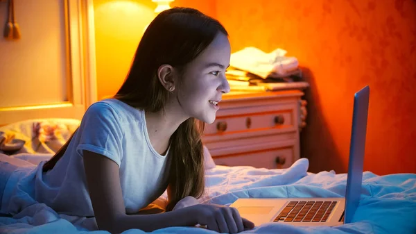 Retrato de la hermosa chica sonriente hablando a través de videollamada en el ordenador portátil por la noche —  Fotos de Stock