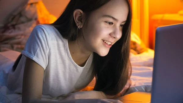 Retrato de bela menina adolescente sorrindo ter chamada de vídeo no laptop à noite — Fotografia de Stock