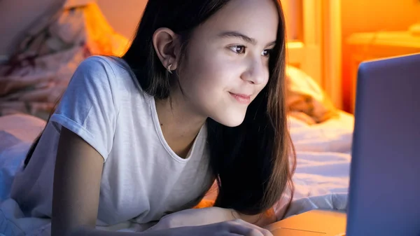 Porträtt av vackra brunett tjej med laptop i sängen — Stockfoto