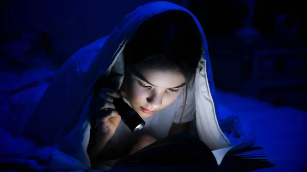 Πορτρέτο του όμορφη κοπέλα με φακό ανάγνωση βιβλίων στο κρεβάτι — Φωτογραφία Αρχείου