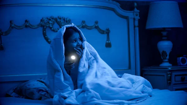 Κορίτσι φοβάται τέρατα που καλύπτονται στην κουβέρτα με φακό — Φωτογραφία Αρχείου