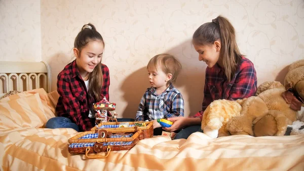 Two happy teenage girls looking after their toddler brother — Stock Photo, Image