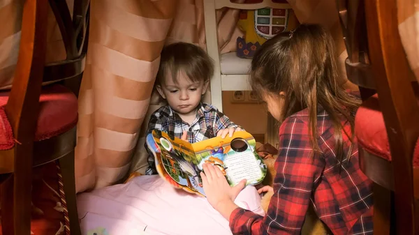 寝室でティーピー テントの中で本を持つ幼児少年の肖像画 — ストック写真