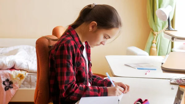 Retrato de chica concentrada haciendo la tarea en el dormitorio —  Fotos de Stock