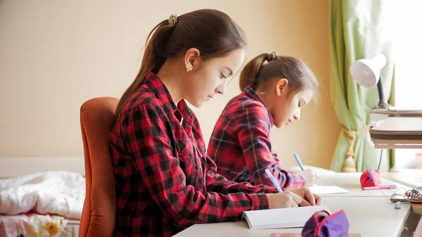 Retrato de meninas adolescentes escrevendo em livros — Fotografia de Stock