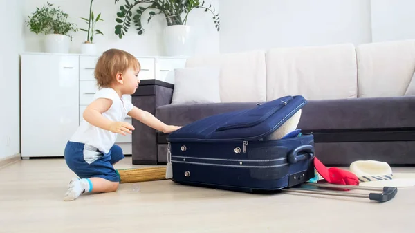 Cute toddler boy packing things in suitcase for traveling — Stock Photo, Image