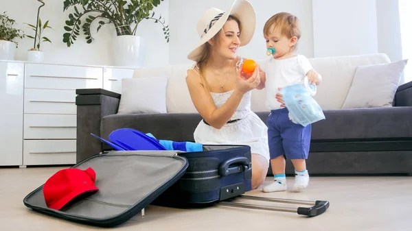 Happy smiling family packing things for summer holiday — Stock Photo, Image