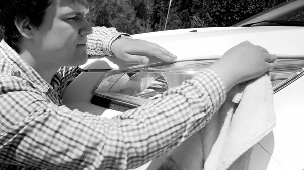 Retrato en blanco y negro del joven lavando faros de coche con tela —  Fotos de Stock