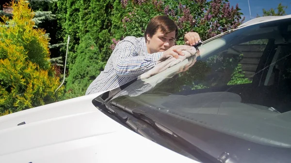 Πορτραίτο νεαρού πλύσιμο του παρμπρίζ του αυτοκινήτου στο κατώφλι του σπιτιού — Φωτογραφία Αρχείου