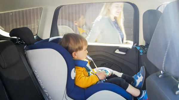 Lindo niño sentado en el asiento de seguridad del coche —  Fotos de Stock