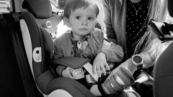 Retrato en blanco y negro del niño sentado en el asiento de seguridad del automóvil —  Fotos de Stock