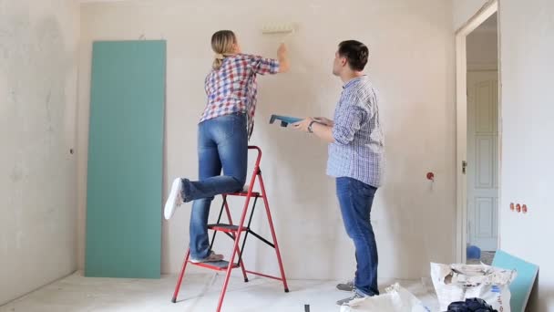 Alegre jovem casal paredes de pintura em sua nova casa — Vídeo de Stock