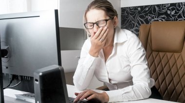 Esneme ve ağzını el ile kapatma overworked genç iş kadını portresi