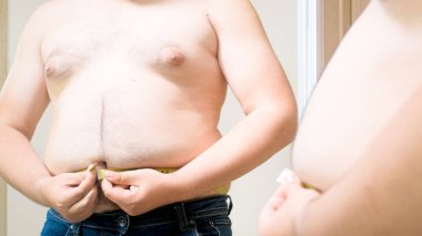 Kilolu delikanlı büyük beline ölçmek için mücadele