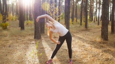 Güzel ince kadın güneşli gün ormanda koşu önce germe