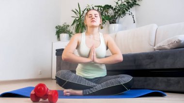 Genç kadın fitness mat yoga uygulamak rahat