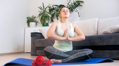 Genç kadın fitness egzersizleri evde yaptıktan sonra meditasyon