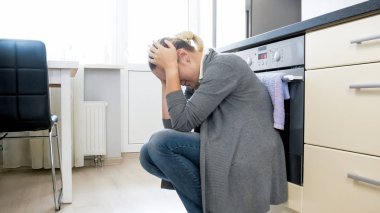 Mutfak katında oturan genç depresif kadın