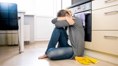 Depresyon mutfak katında oturan genç ev hanımı