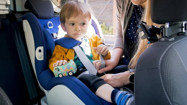 Foto de primer plano de los cinturones de sujeción de la madre en el asiento de seguridad de su hijo — Foto de Stock
