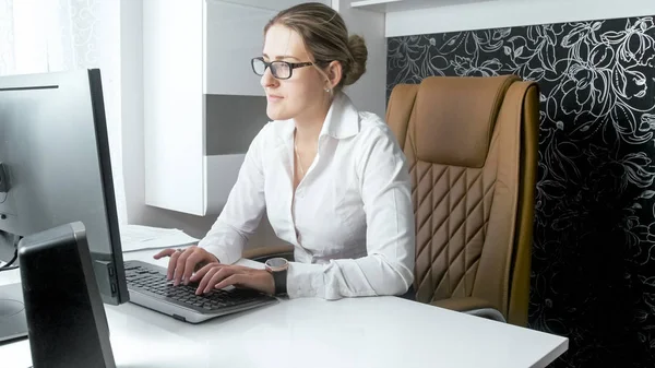 Mooie elegante zakenvrouw in witte blouse zittend in lederen stoel — Stockfoto