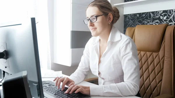 Портрет улыбающейся деловой женщины, работающей за компьютером в офисе — стоковое фото