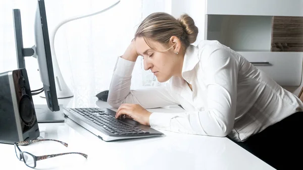 Retrato de mulher cansada lening trabalhador na mão enquanto trabalhava no computador — Fotografia de Stock