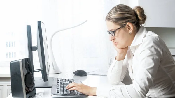 Портрет грустной молодой предпринимательницы, работающей за компьютером — стоковое фото