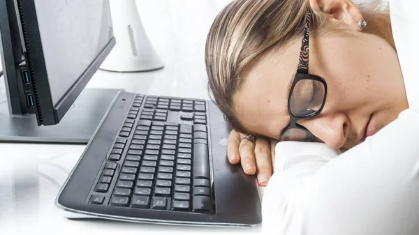 Портрет измученной молодой женщины заснул на столе в офисе — стоковое фото