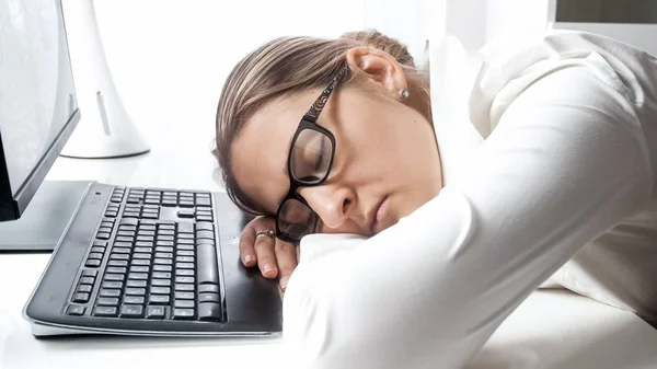 Молодой измученный офисный работник спит на столе — стоковое фото
