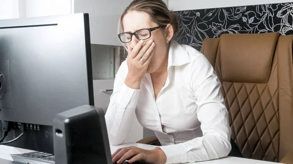 Portrait of exhausted businesswoman yawning while working at office — Stock Photo, Image