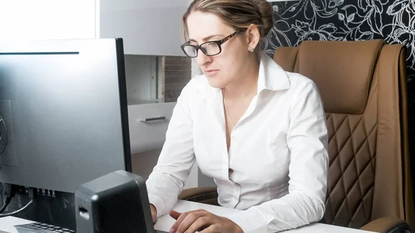 Mooie jonge vrouw in brillen geconcentreerd op kantoorwerk — Stockfoto