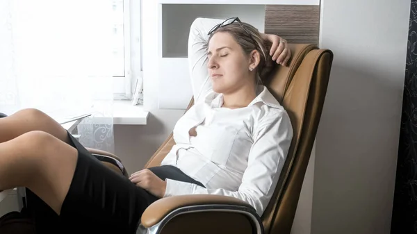 Porträtt av ung affärskvinna sover i stora kontorsstol — Stockfoto