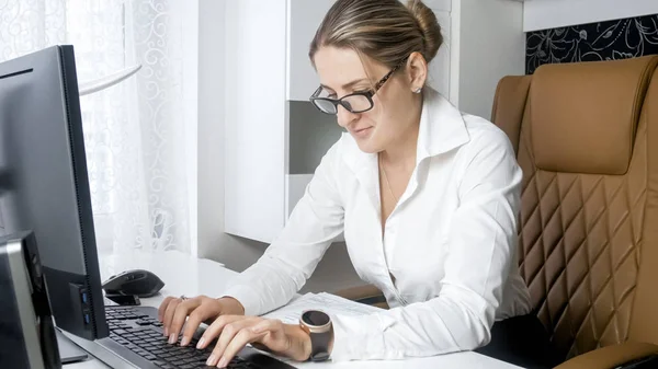オフィス内のコンピューターにテキストを入力する集中の若い女性の肖像画 — ストック写真
