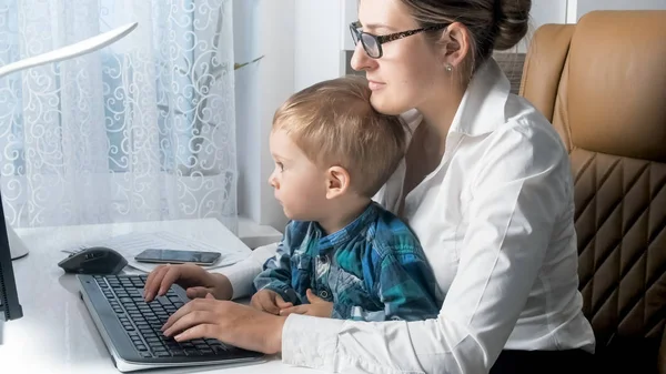 Vacker ung kvinna tog sin toddler pojke till sitt arbete i office — Stockfoto