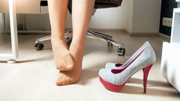 Primeros planos de la joven empresaria masajeando los pies adoloridos en pantimedias — Foto de Stock