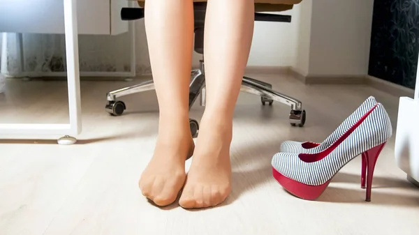 Junge barfüßige Frau entspannt sich nach dem Tragen von High Heels im Büro — Stockfoto