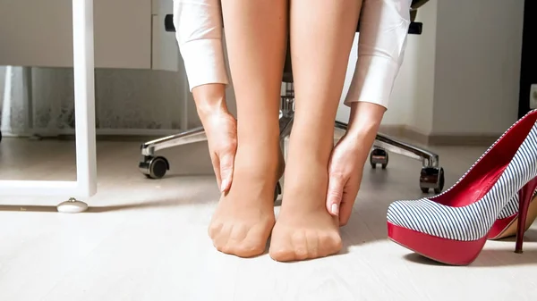 Foto di primo piano di donna d'affari a piedi nudi toccare i suoi piedi stanchi doloranti — Foto Stock
