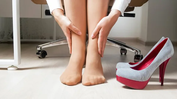 Nahaufnahme einer jungen Geschäftsfrau, die nach dem Tragen unbequemer High Heels unter Fußschmerzen leidet — Stockfoto