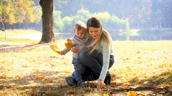 Glad ung mor med småbarn son på hösten park — Stockfoto