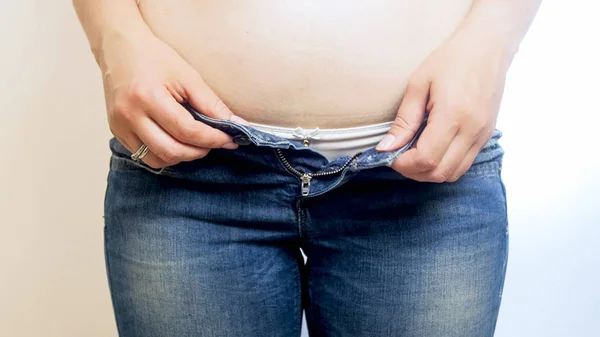 肥胖妇女挣扎着穿紧身牛仔裤特写照片 — 图库照片