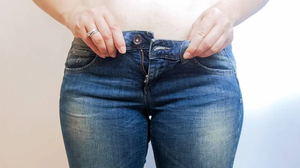 Foto de primer plano de una mujer joven con vientre usando jeans — Foto de Stock