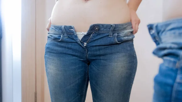Nahaufnahme einer jungen Frau, die ihren dicken Bauch im Spiegel betrachtet — Stockfoto